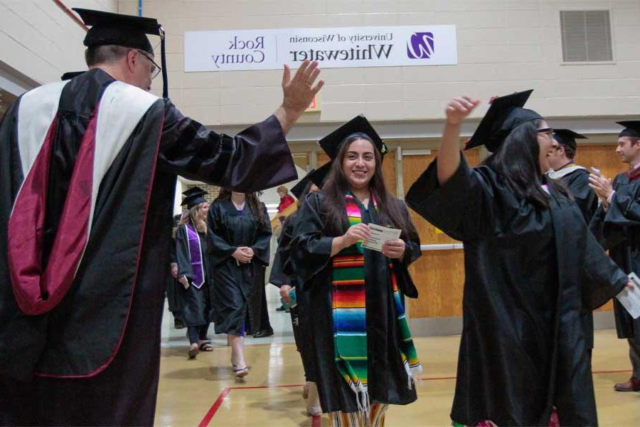 Students at commencement are cheered on by faculty.