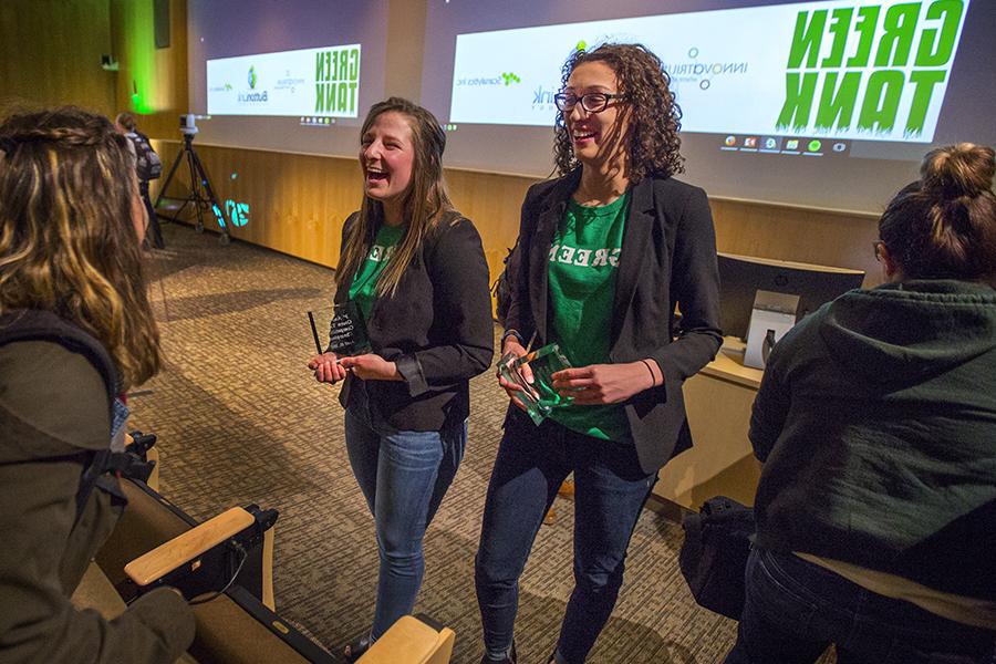 Two students standing together wear green T-shirts that say Green Tank.