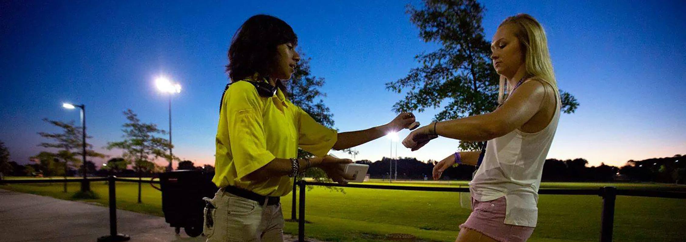 Woman stamping another woman's hand at a university event